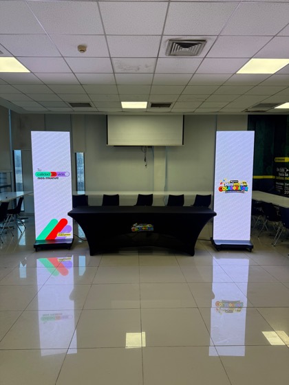 Dos pendones LED flanqueando la mesa principal en una jornada interna de Chilexpress